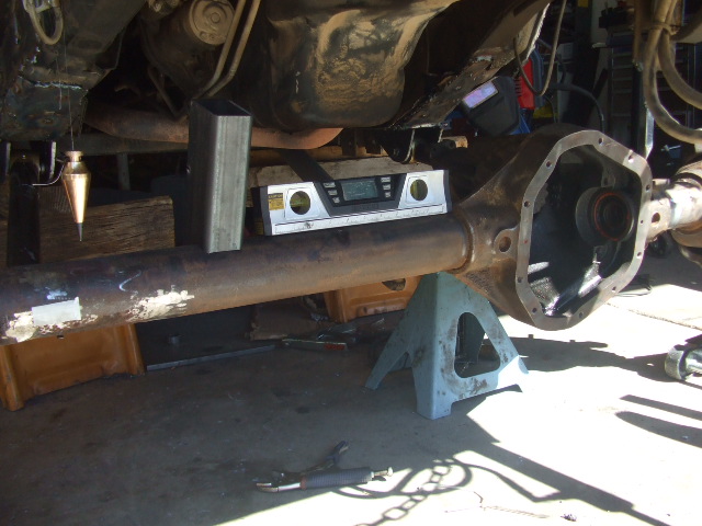 Solid rear axle housing under a vehicle with a digital level checking pinion angle