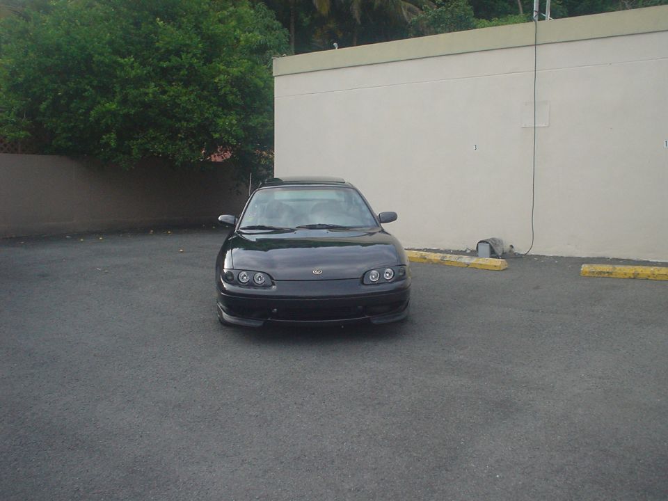 Black 1993 Mazda MX-6 coupe parked in front of a building