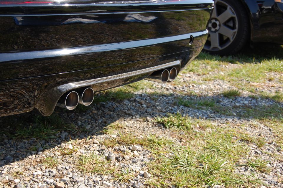 Black BMW M3 rear bumper with quad exhaust tips and carbon fiber trim