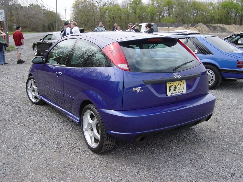Rear of a purple Ford Focus SVT hatchback with NJ plate, people gathered
