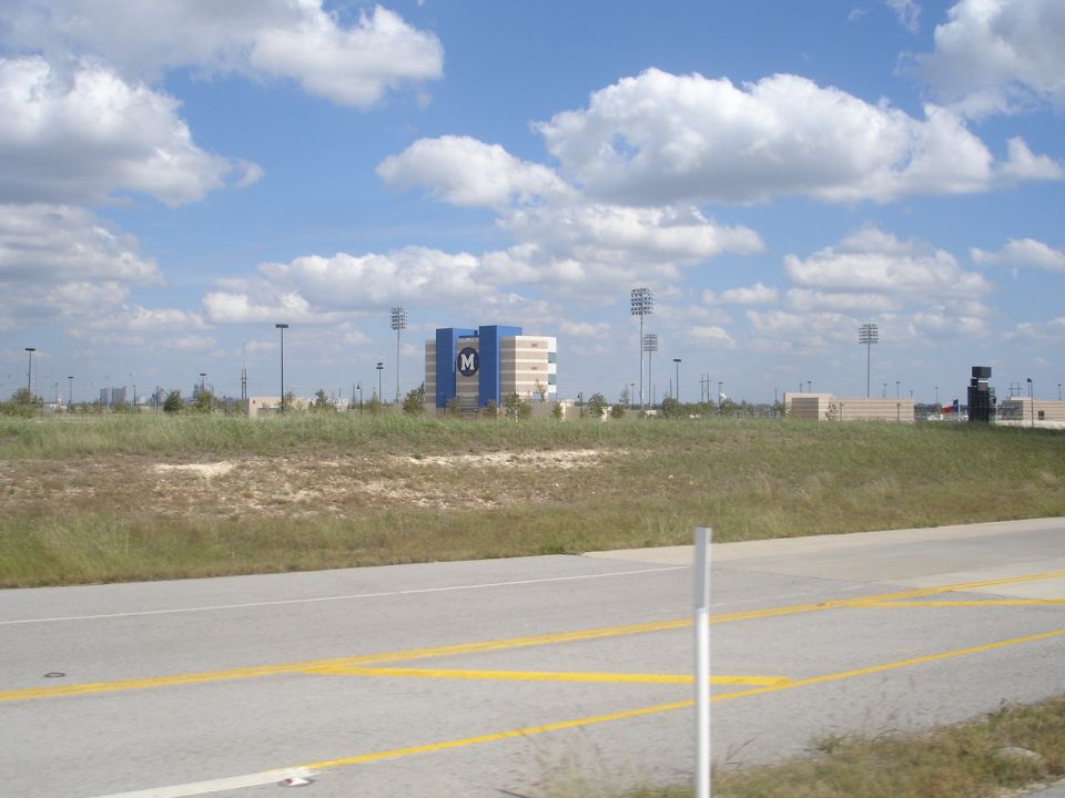 Building with large M logo against a cloudy blue sky