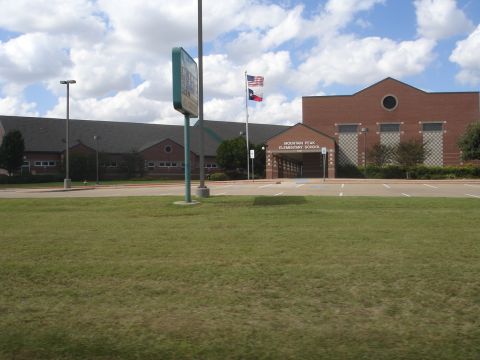 1989 Ford Bronco - The image shows the front of Mountain Peak Elementary School on a cloudy day. The school is a brick building with a large entrance and flag…