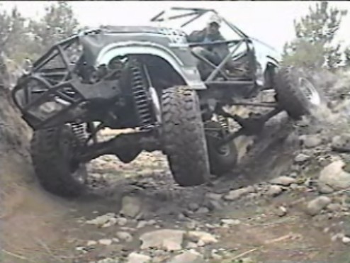 Heavily modified off-road vehicle on a steep, rocky incline.