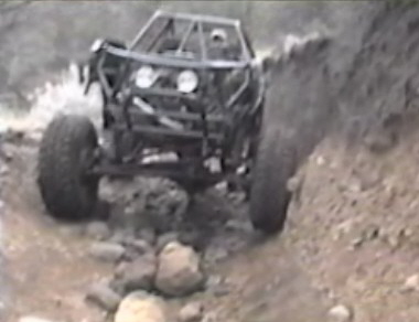 1984 Ford Bronco - A heavily modified off-road vehicle, likely a custom build based on a 1984 Ford Bronco, navigates a rocky, dirt trail. The vehicle features…