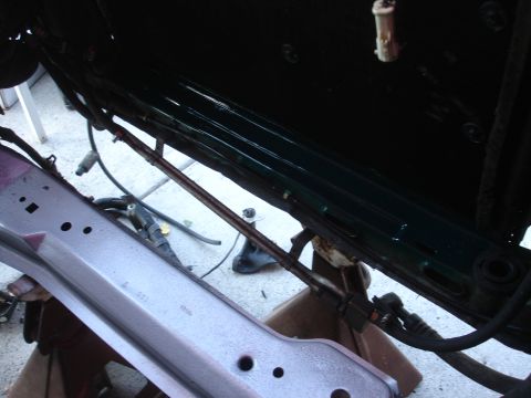 1993 Ford Taurus - The undercarriage of a vehicle is visible, supported by jack stands, with various mechanical components and wiring present.