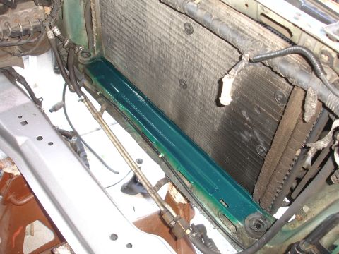 1993 Ford Taurus - Close-up view of a vehicle's radiator and surrounding engine bay components, with a pool of green fluid visible.