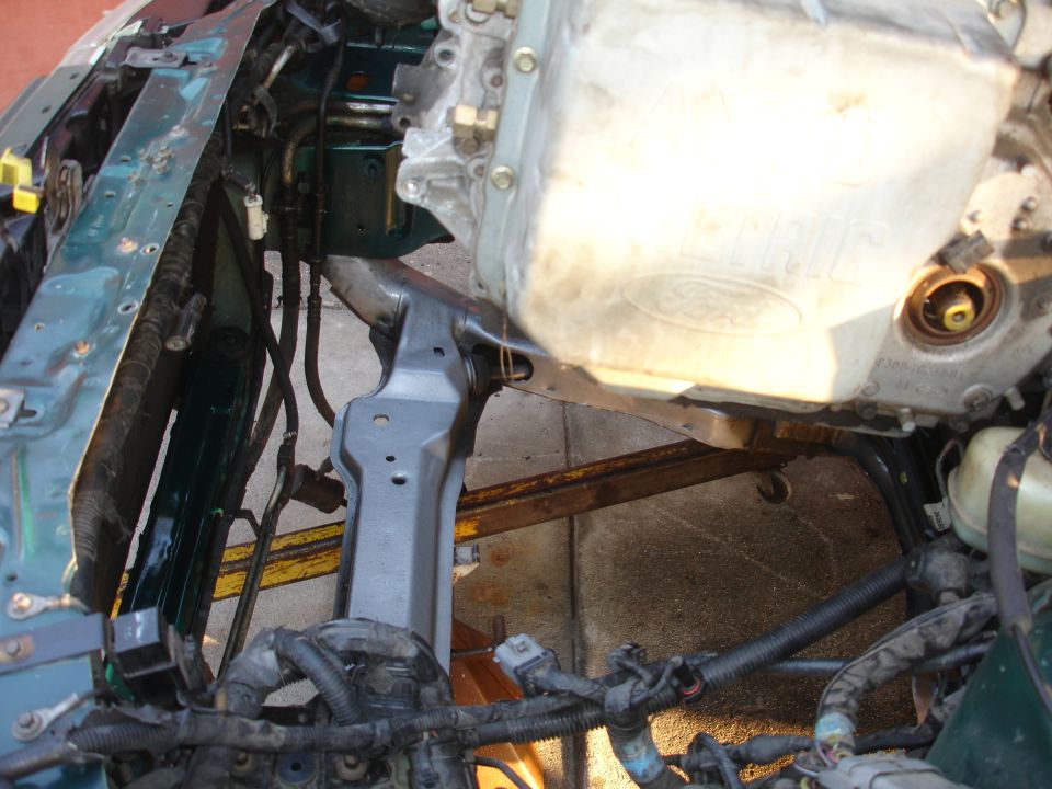 1993 Ford Taurus engine bay with green body panels and silver oil pan