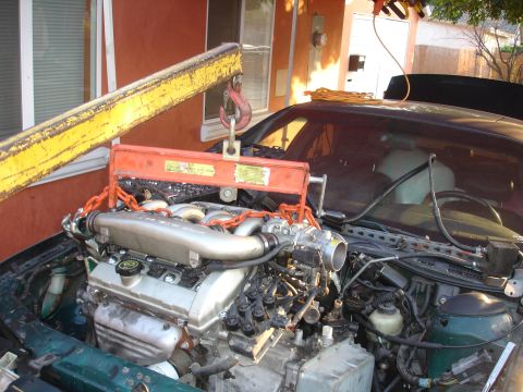 1993 Ford Taurus - Engine hoist lifting the engine out of a 1993 Ford Taurus during a rebuild.