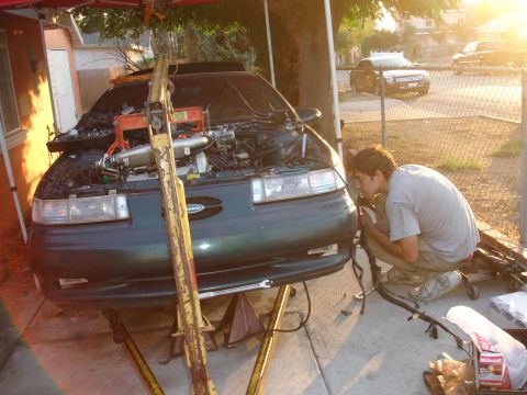 1993 Ford Taurus - Mechanic works on the wiring of a 1993 Ford Taurus undergoing repairs.