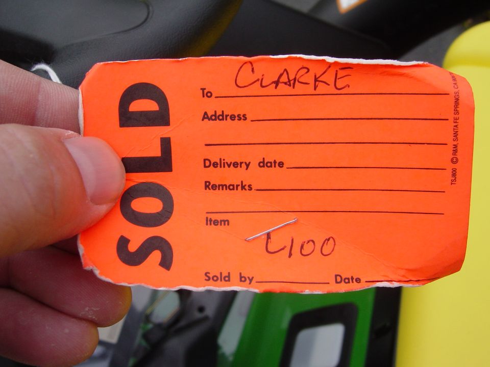 Orange sold tag with handwritten 'CLARKE' and '4100'