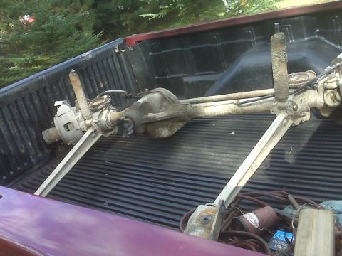 1996 Ford Bronco - A disassembled rear axle assembly is loaded into the bed of a pickup truck.