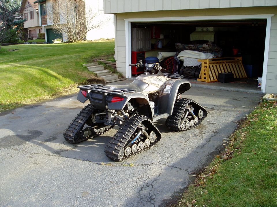 ATV with tracks instead of wheels parked in driveway