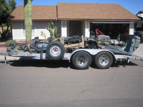 1994 Ford Bronco - A disassembled vehicle is loaded onto a trailer, ready for transport.
