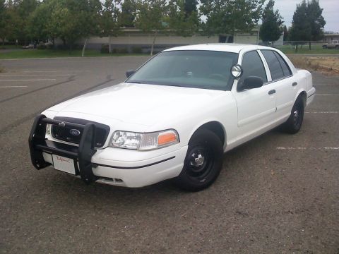 2000 Ford Crown Victoria - This 2000 Ford Crown Victoria, equipped with a push bumper and spotlight, is seen from a three-quarter front view.