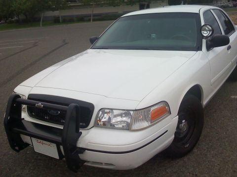2000 Ford Crown Victoria - Front view of a white 2000 Ford Crown Victoria police car equipped with a push bar and spotlight.