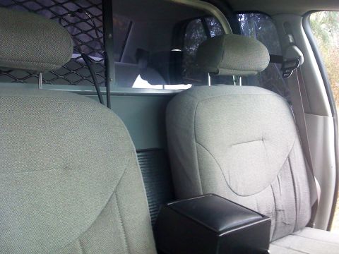 2000 Ford Crown Victoria - The interior of a vehicle, cloth seats and a protective mesh barrier.