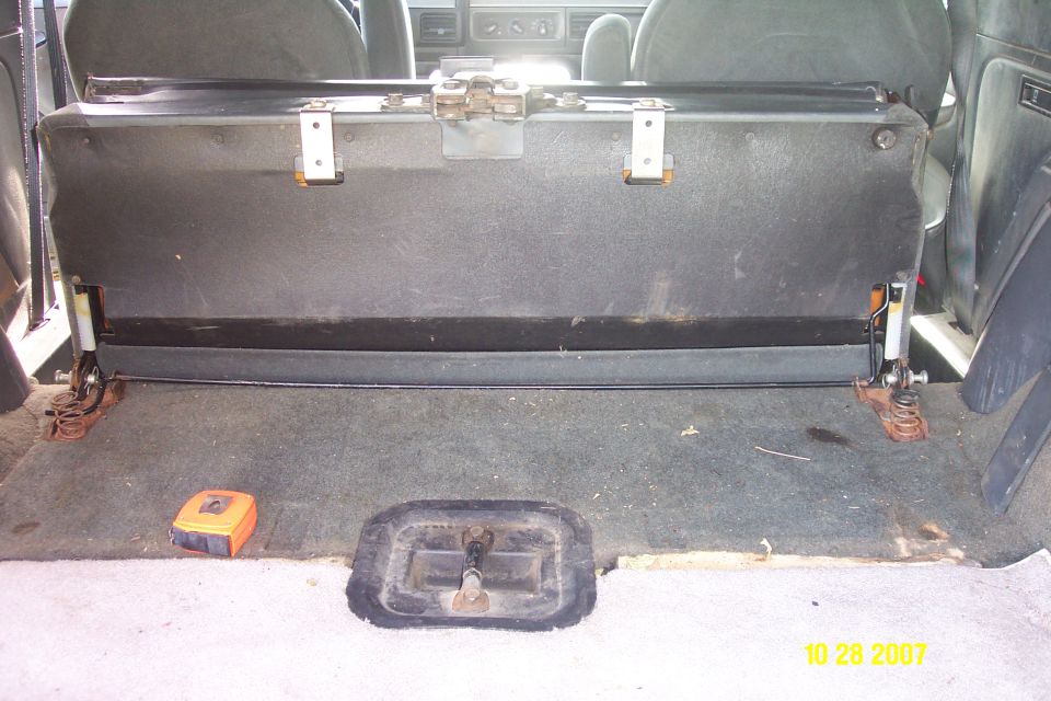 1992 Ford Bronco back seat folded up, showing carpet and metal brackets