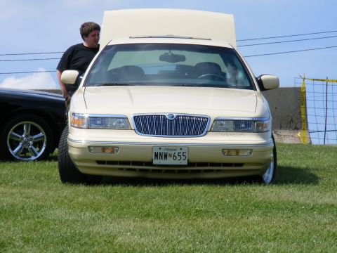 1997 Mercury Grand Marquis - A 1997 Mercury Grand Marquis is shown from the front with its hood open, parked on grass next to another vehicle.