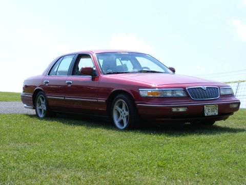 1997 Mercury Grand Marquis - This 1997 Mercury Grand Marquis is shown from a 3/4 front angle on a grassy field.