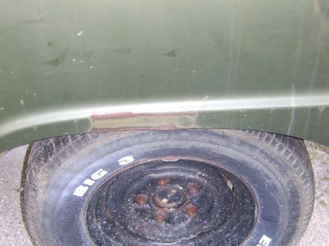 1976 Ford Bronco - Close-up of a spare tire and a rusted area on a vehicle's fender.