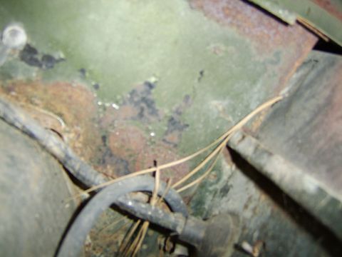 1976 Ford Bronco - Close-up view of rusted metal components with visible wiring and hoses.