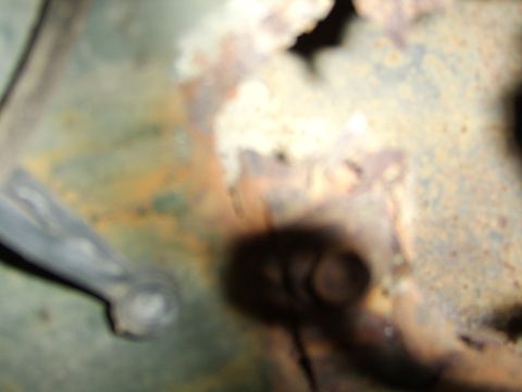 1976 Ford Bronco - Close-up of heavily rusted metal, with a dark shadow obscuring any potential vehicle parts or details.