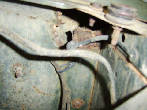 1976 Ford Bronco - This image shows a close-up of a vehicle's inner fender well, revealing significant rust and exposed wiring.