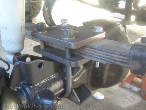 1987 Suzuki Samurai - Close-up view of a custom axle modification with leaf springs and U-bolts.