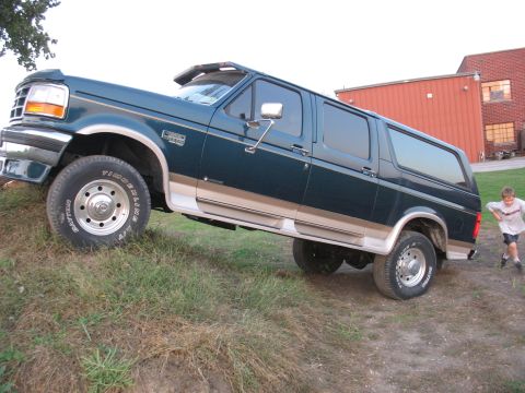 1995 Ford C-350 (Centurion Conversions) - This extended SUV has a two-tone paint scheme and is parked on a slight hill.