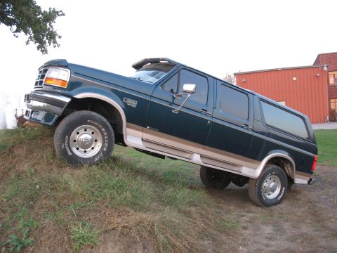 1995 Ford C-350 (Centurion Conversions) - This SUV, likely a 1992 model, is parked on a grassy slope with a building in the background.