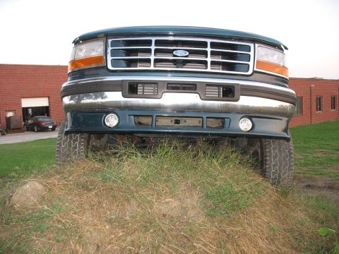 1995 Ford C-350 (Centurion Conversions) - Front view of a 1995 Ford C-350 (Centurion Conversions) truck, partially obscured by grass.