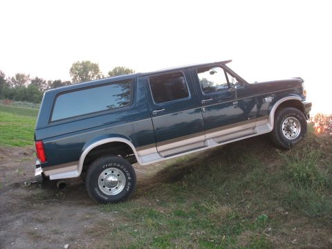 1995 Ford C-350 (Centurion Conversions) - This 1995 Ford C-350 Centurion Conversions extended SUV features a dark green exterior with tan trim and is shown in a three-quarter front…