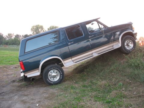 1995 Ford C-350 (Centurion Conversions) - Side view of a 1995 Ford C-350 Centurion Conversion van on a dirt and grass slope.