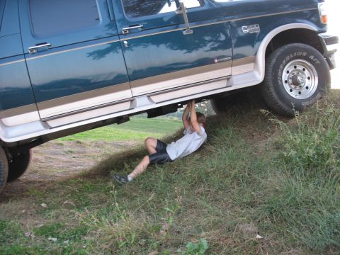1995 Ford C-350 (Centurion Conversions) - Person working on the undercarriage of a 1995 Ford C-350 (Centurion Conversions).