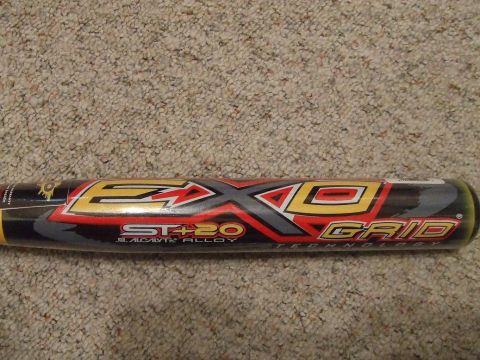 1987 Ford Bronco - A baseball bat with prominent 'EXO GRID' branding and 'ST+20 SCALOY ALLOY' text is shown against a carpeted background.