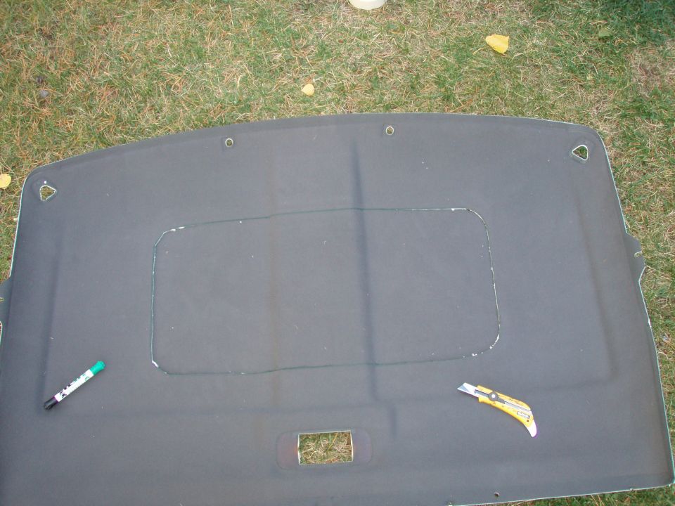 after measure it 99 times i centered the plastic insert ring and taped it down, then drew a line with a felt marker NEATLY.
i cut the hole in the headliner with a carpet knife