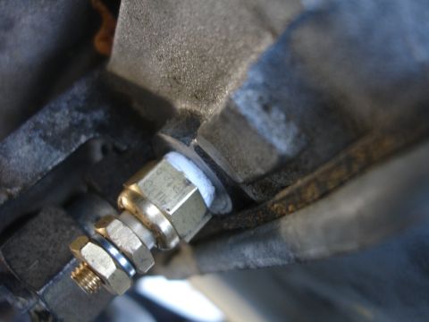 1993 Ford Taurus - A brass fitting with sealant is attached to a metal component.