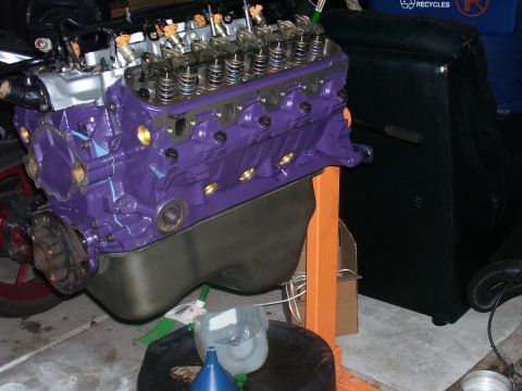 1991 Ford Bronco - A purple V8 engine is mounted on an orange engine stand, ready for installation or undergoing work.