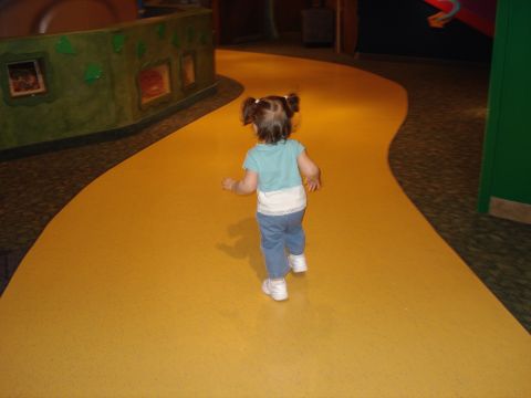 2000 Ford Crown Victoria - A young child walks along a winding yellow path within an exhibit space.