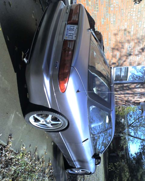 1994 Ford Probe - A silver hatchback is parked on a driveway, viewed from the rear three-quarter angle.