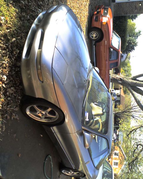 1994 Ford Probe - A silver 1994 Ford Probe is parked next to an orange pickup truck in a driveway.