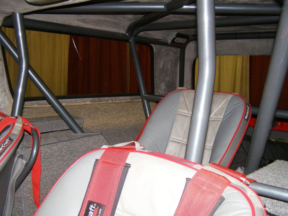 Bronco interior with gray MasterCraft seats, red harnesses, and gray roll cage tubing