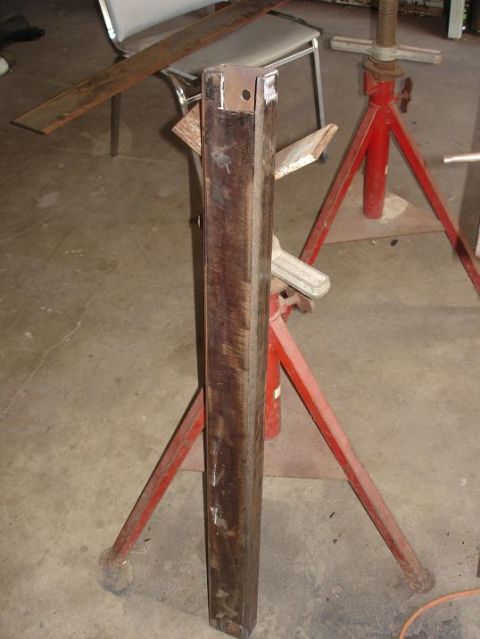 1996 Ford F-150 - A metal beam is held up by two red jack stands in a garage setting.