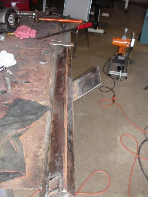 1996 Ford F-150 - Metal frame part on a workbench, with tools and a chop saw nearby.