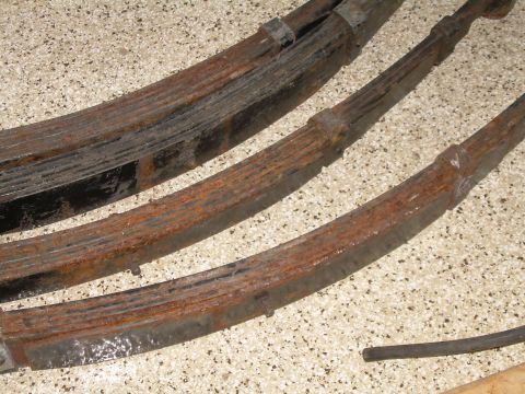 1986 Ford Bronco - Several heavily rusted leaf springs are shown in a close-up view.