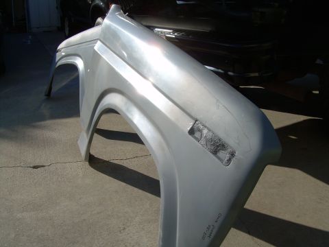 1986 Ford Bronco - A single silver fender is shown, likely a replacement part, with visible damage to the light housing area.