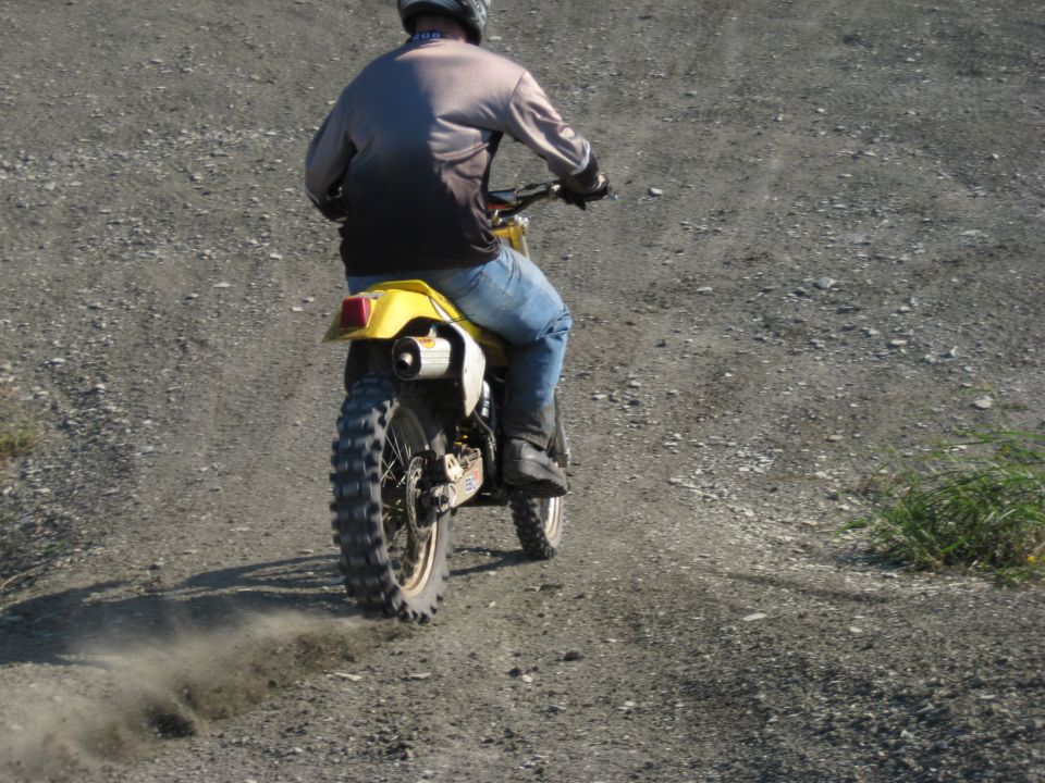 Yellow dirt bike rear view on dusty trail