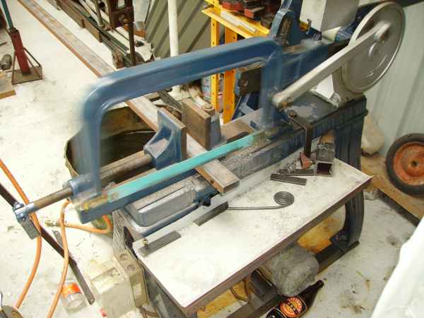 Band saw cutting metal in a workshop