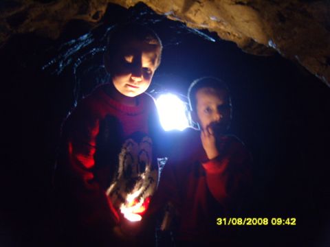 1989 Ford Bronco - Children explore a dark cave, illuminated by a bright light source, with a date stamp in the corner.