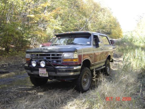 1994 Ford Bronco - This 1994 Ford Bronco navigates a muddy trail surrounded by autumn foliage.